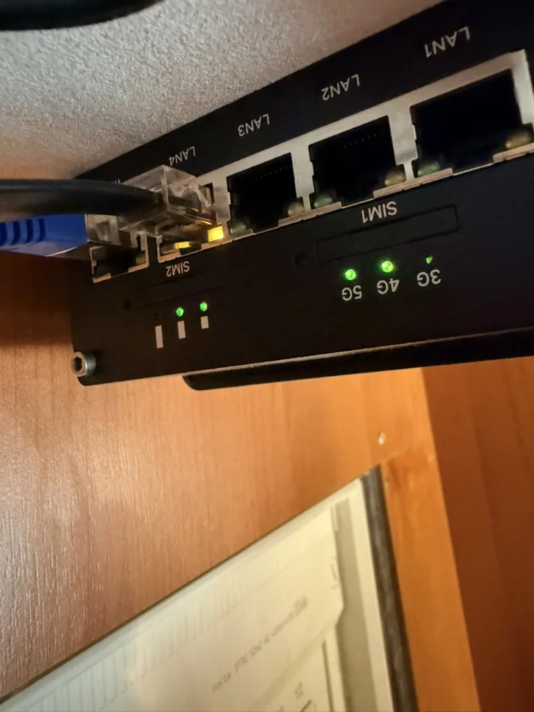 Detailaufnahme des Routers Teltonika RUTX50 mit Status-LEDs der Mobilfunknetze und angeschlossenem Ethernet-Kabel